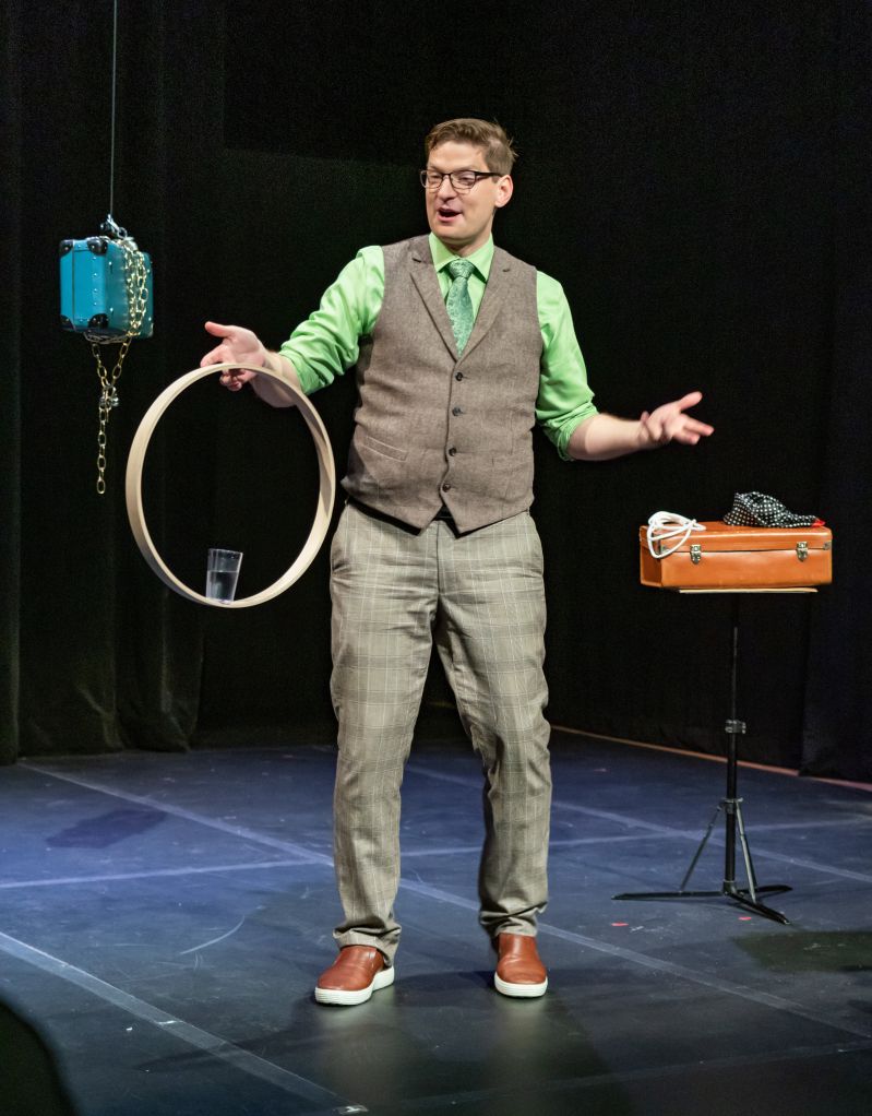 Ryan Pilling performing an interactive magic trick on stage